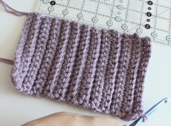 a section of lavender yard crocheted into the first steps of a beginner friendly hat and matching mittens
